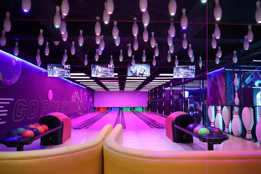 Bowling alley with purple and pink decor, including bowling lanes and pins.