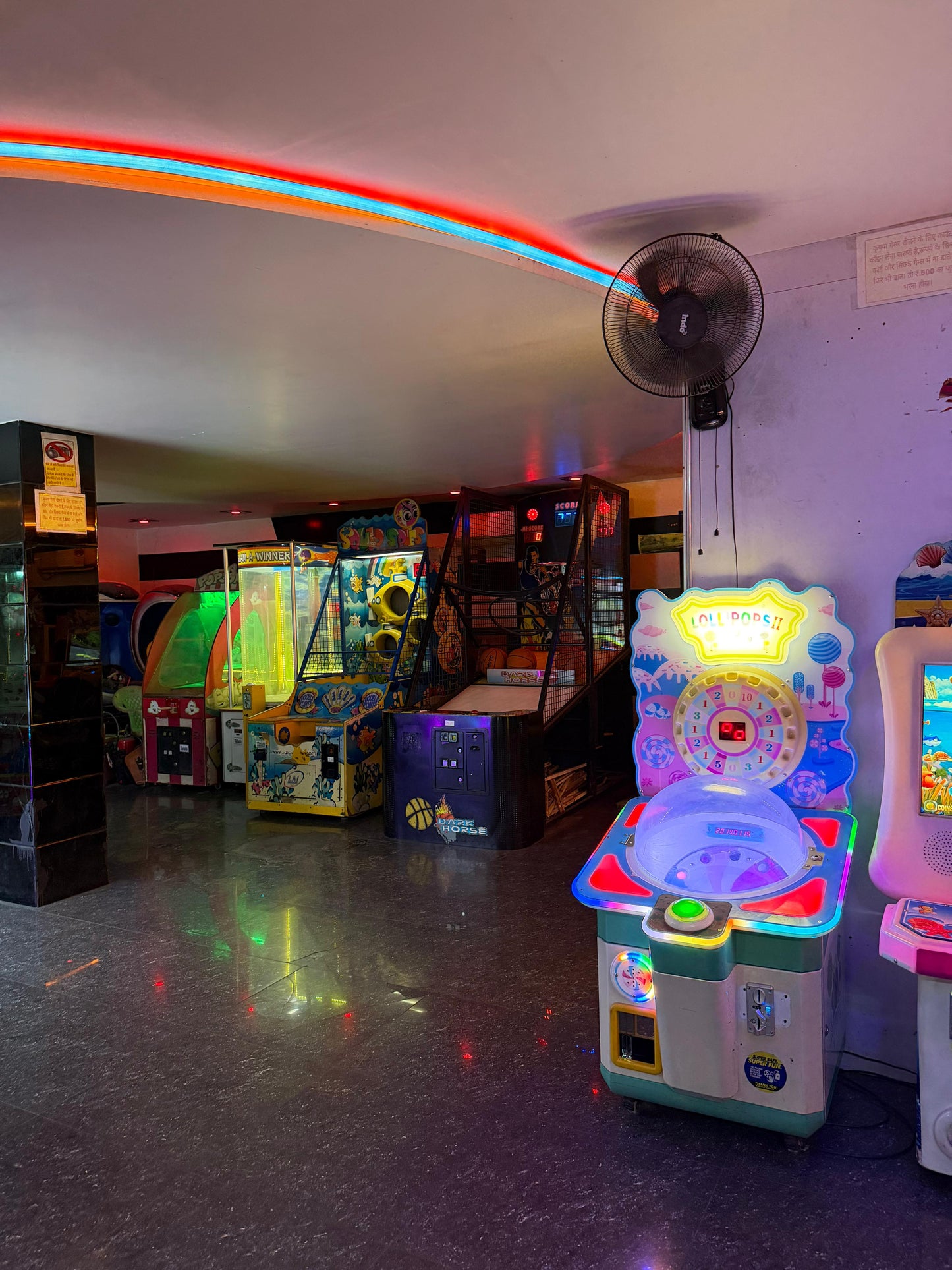 An arcade with colorful game machines and neon lights.