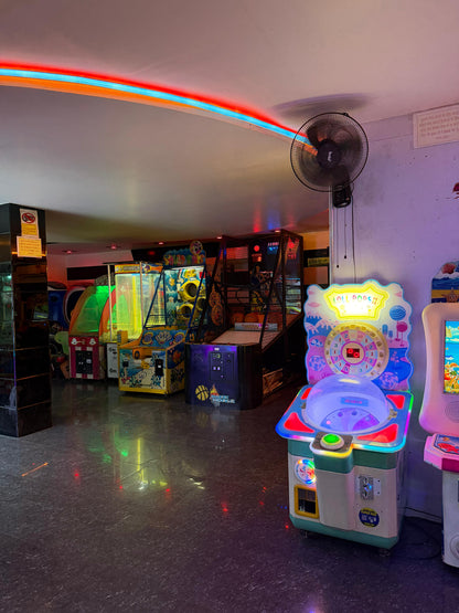 An arcade with colorful game machines and neon lights.