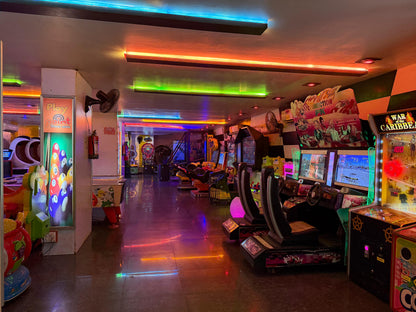 An arcade with colorful neon lights and various game machines.