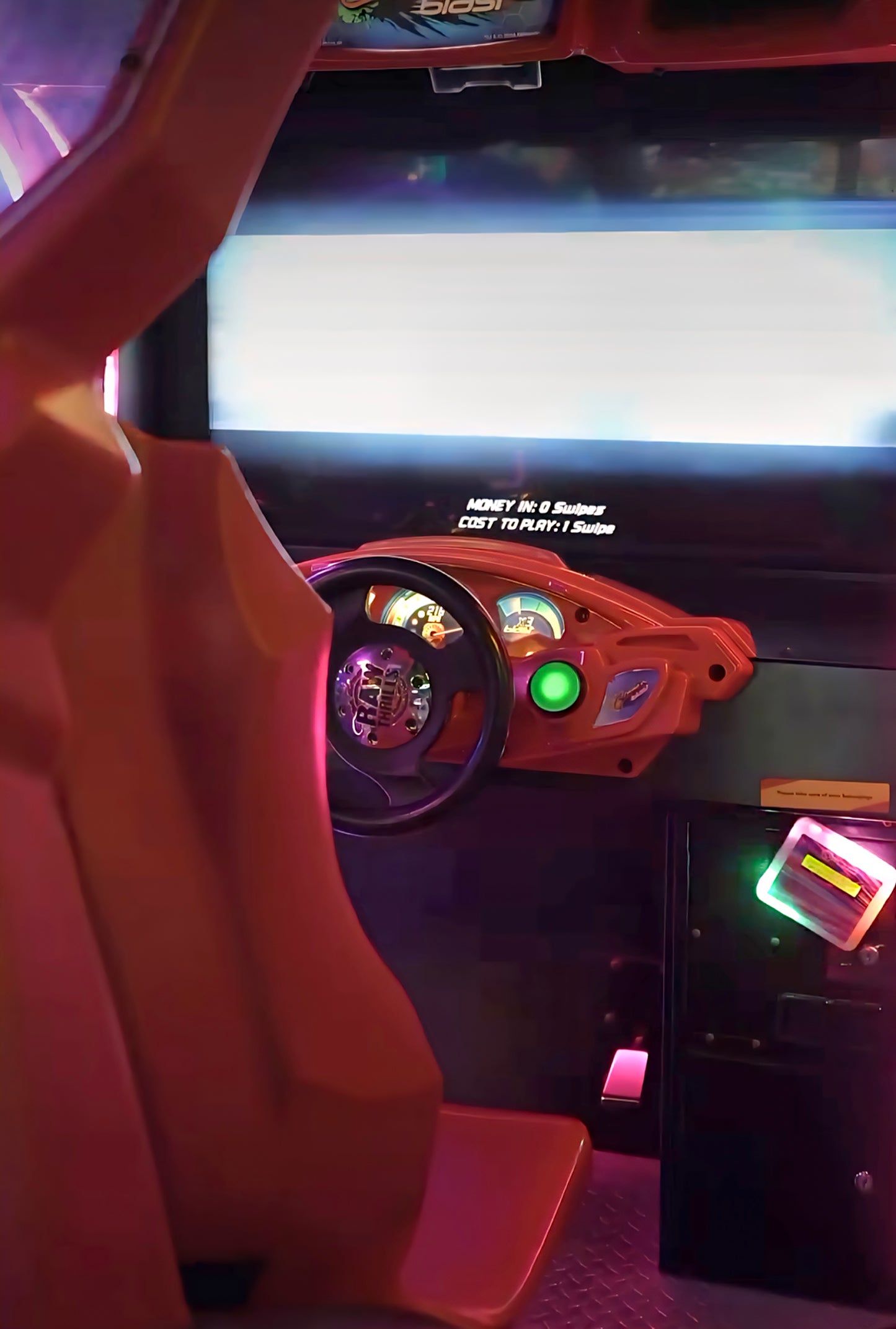 Arcade racing game with a steering wheel and dashboard.