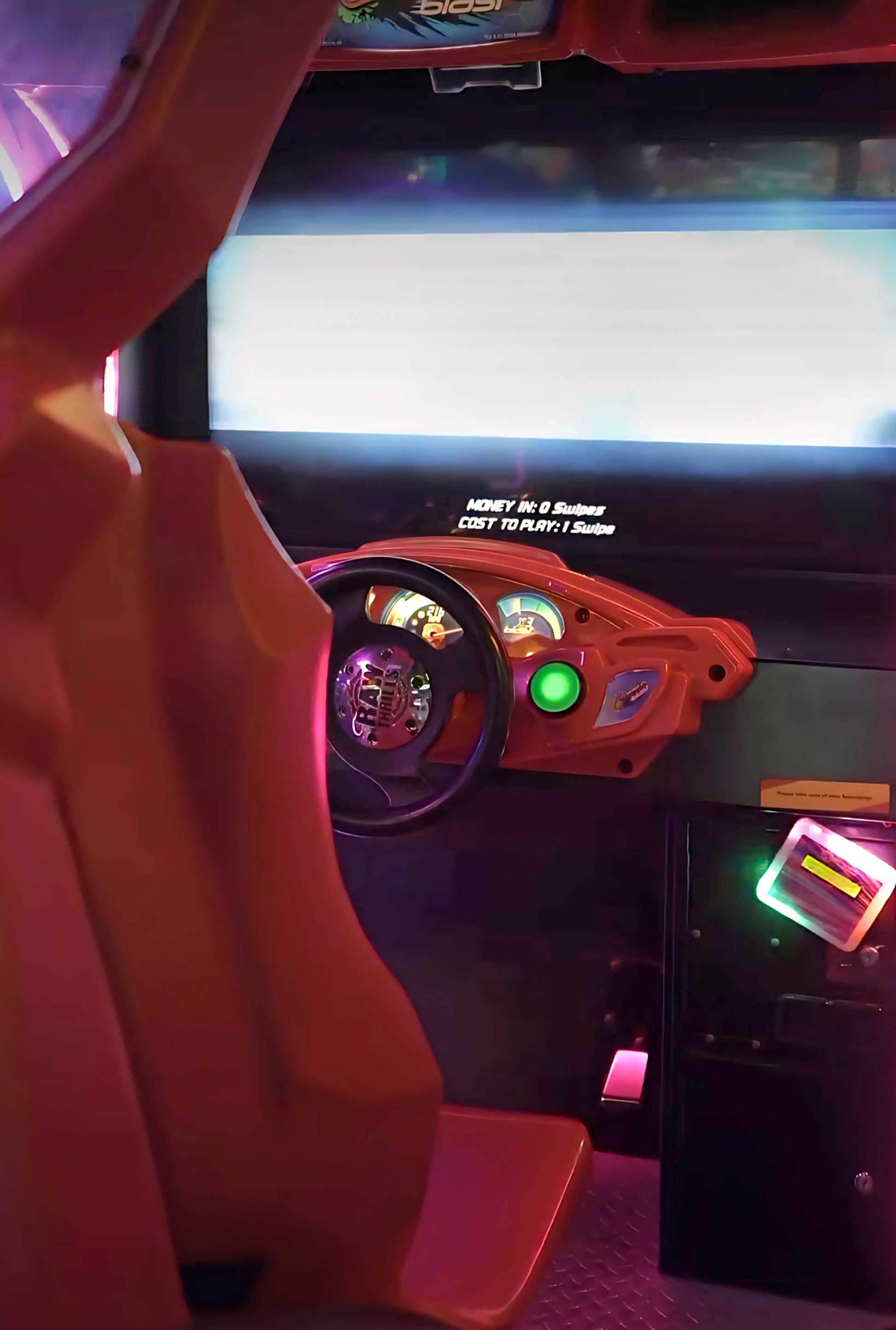 Arcade racing game with a steering wheel and dashboard.