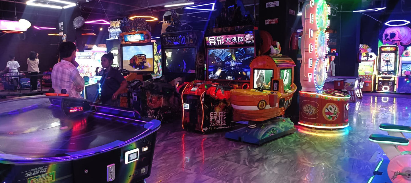 An arcade with various games and people playing.