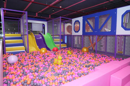 A colorful indoor playground with slides, a ball pit, and climbing structures for children.