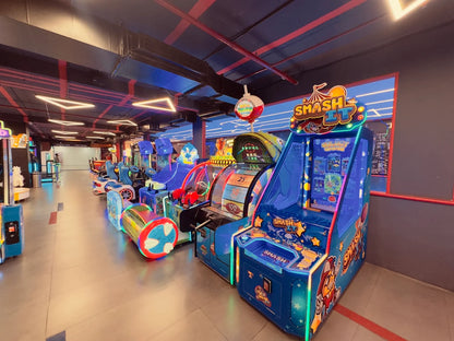 An arcade with rows of colorful, brightly lit video games, including a "Smash It" game.