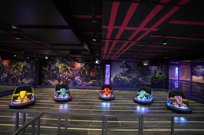 Bumper cars with superhero murals in an indoor amusement area.