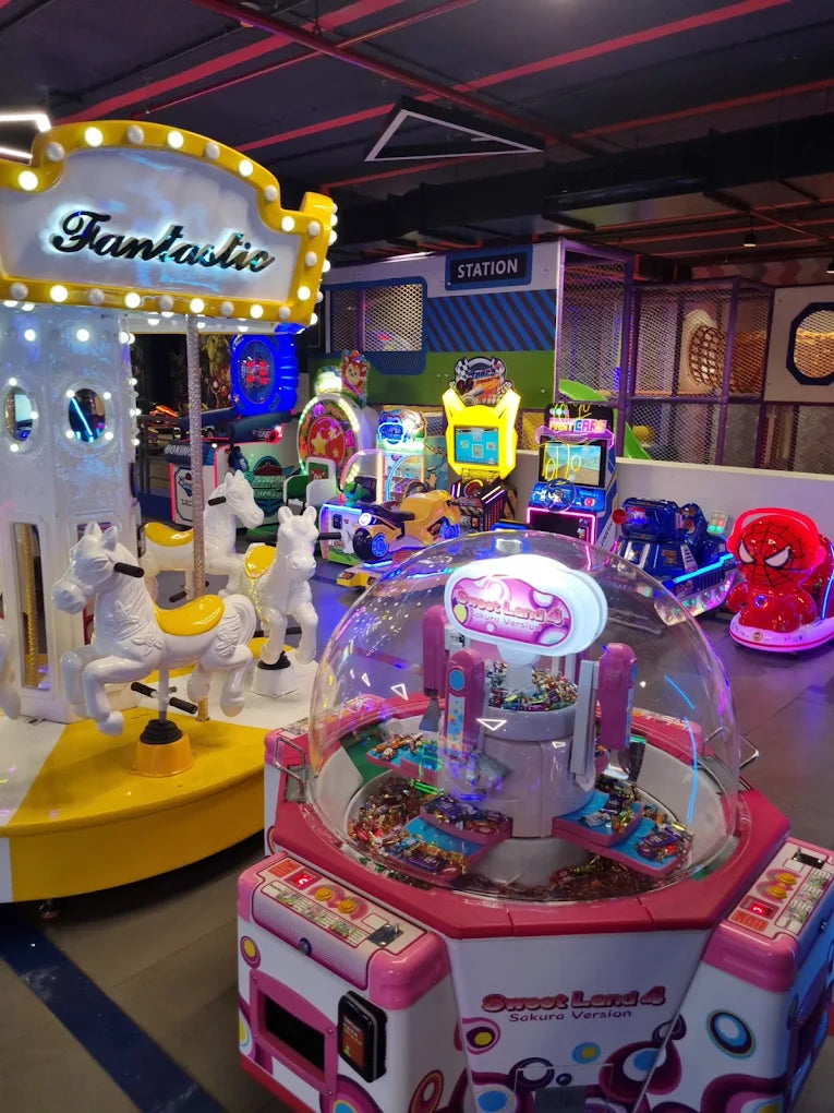 An indoor amusement arcade with a carousel, arcade games, and a claw machine.