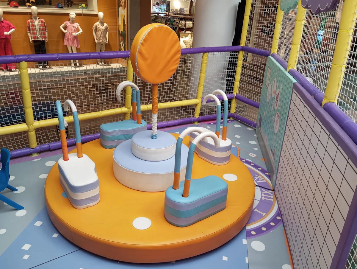 A colorful indoor playground with soft play equipment for young children.