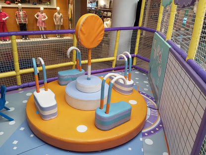 A colorful indoor playground with soft play equipment for young children.