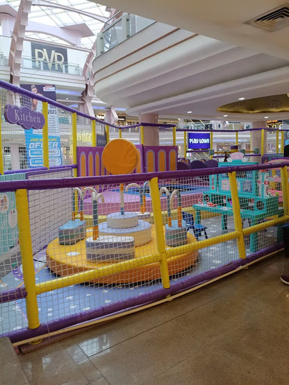 A colorful indoor playground for children with soft play structures and a "Play Town" sign.