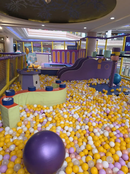 A colorful ball pit with slides and play structures, filled with children's toys.