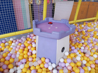 A ball pit with colorful balls and a castle-themed play structure.