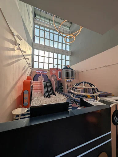 Indoor playground with ball pit, slides, and climbing structures for children.