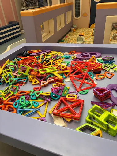 A bin of colorful magnetic building toys for children.