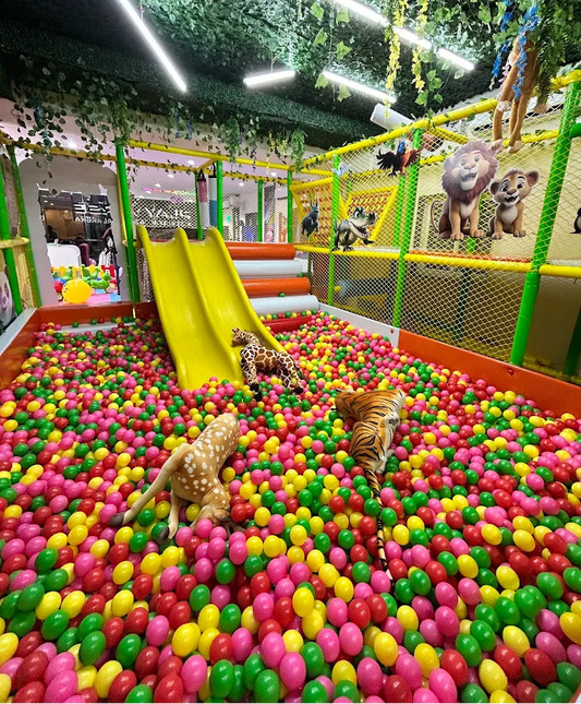 A colorful ball pit with stuffed animals and a slide, designed for children's play.
