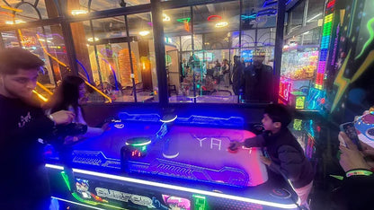 Children play an arcade game in a brightly lit entertainment center.