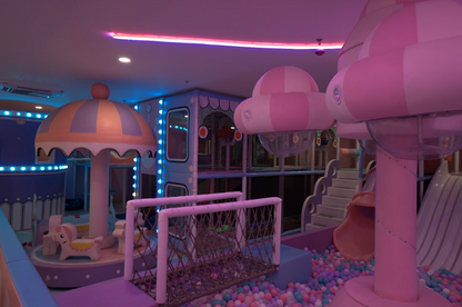 A colorful indoor playground with ball pits, slides, and soft play structures for children.