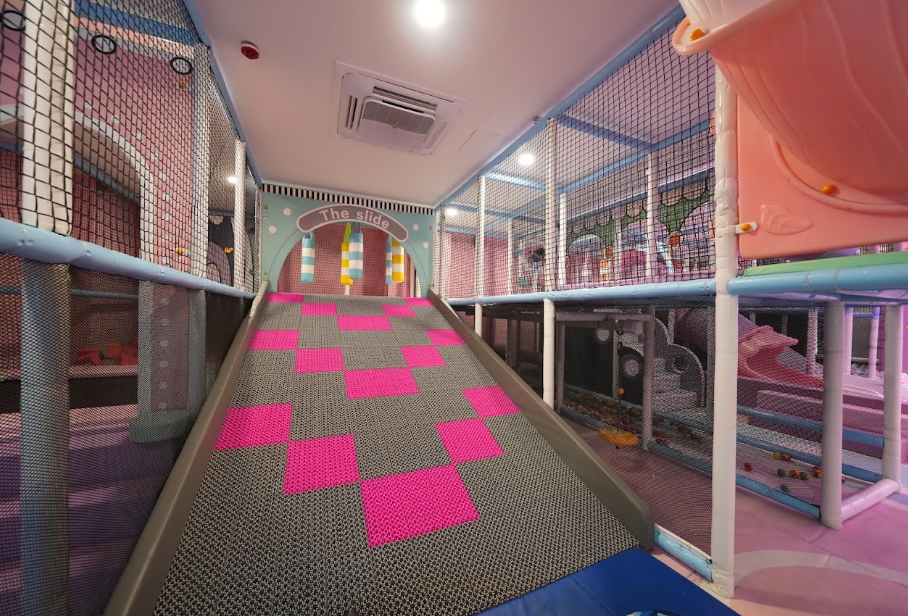A colorful indoor playground with a slide and soft play areas for children.