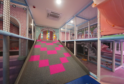 A colorful indoor playground with a slide and soft play areas for children.