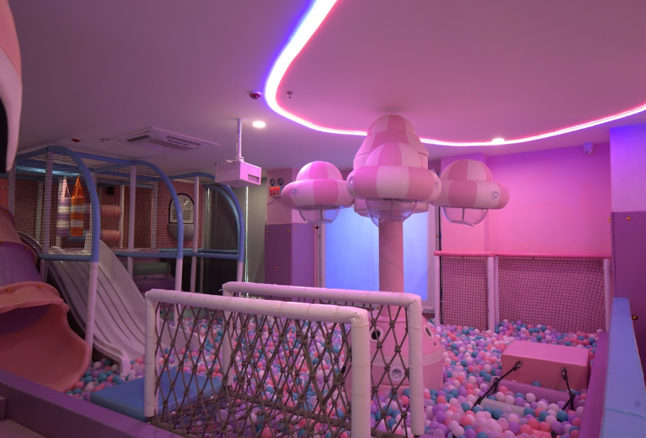A colorful indoor playground with slides, ball pits, and soft play structures for children.
