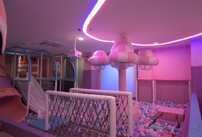 A colorful indoor playground with slides, ball pits, and soft play structures for children.