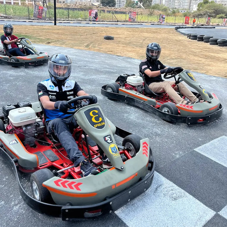 Adults race go-karts on an outdoor track.