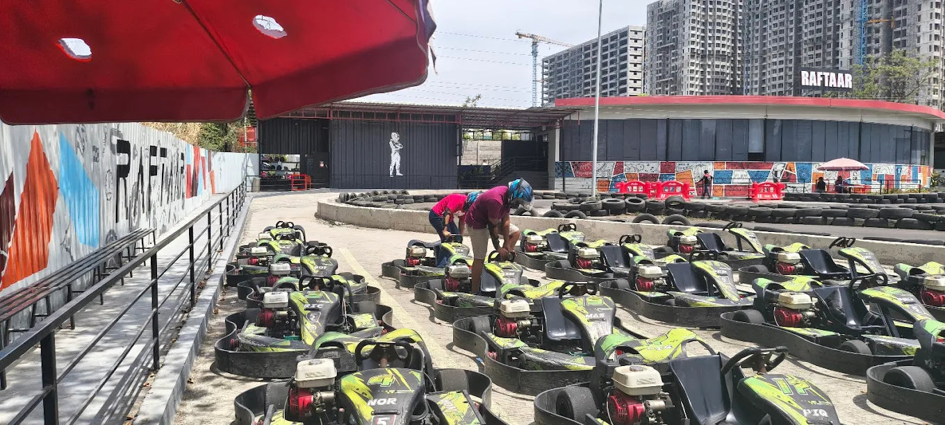 Go-karts lined up at a track with people preparing to race.