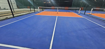A blue and orange tennis court with nets and white lines.