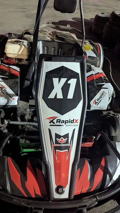 A go-kart with "X1" branding and red and black graphics.