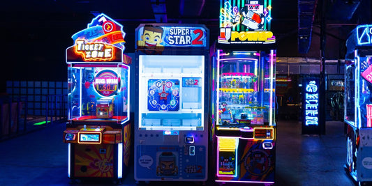 Arcade games glow with neon lights in a dimly lit arcade.