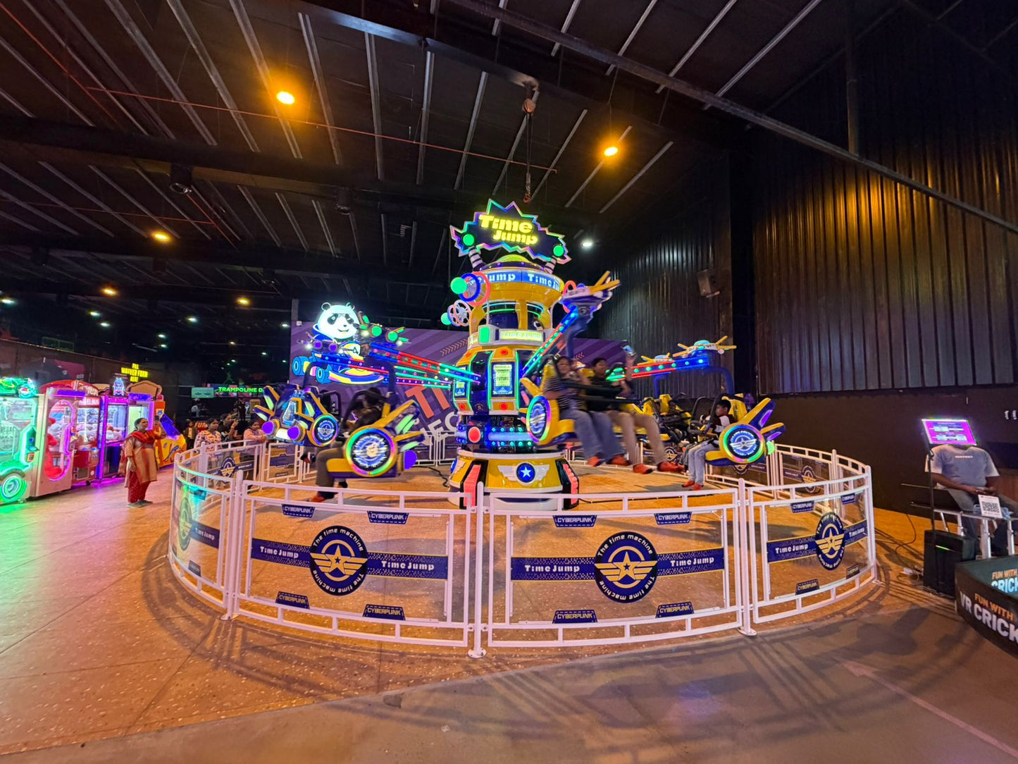 A colorful amusement park ride with children and adults enjoying the spinning attraction.
