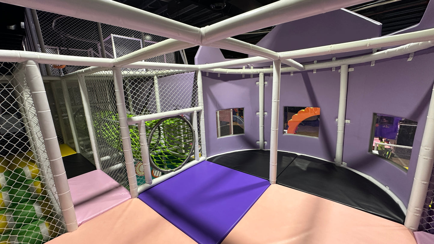 A colorful indoor playground with soft mats and netting for children.