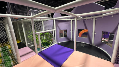 A colorful indoor playground with soft mats and netting for children.