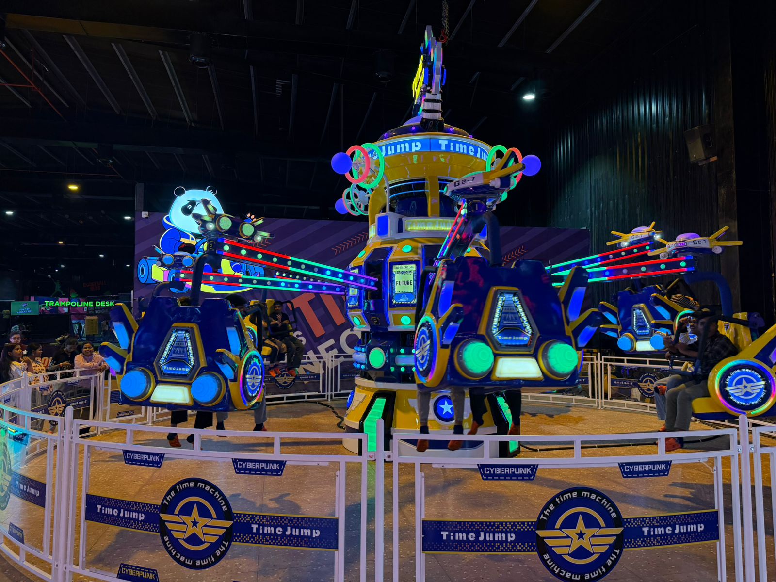 A colorful amusement park ride with young people enjoying the "Time Jump" attraction.