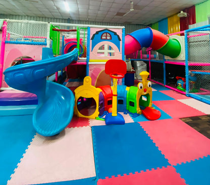 A colorful indoor playground with slides, tunnels, and a basketball hoop for young children.