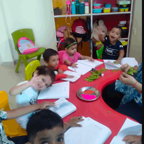Children sitting around a table with art supplies in a classroom setting