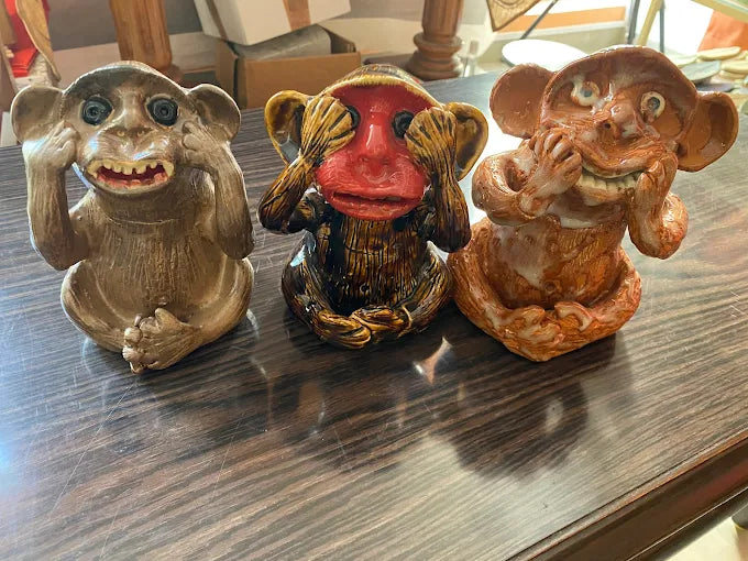 Three monkey figurines made of clay / pottery on a surface