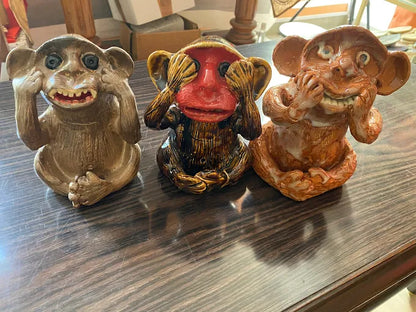 Three monkey figurines made of clay / pottery on a surface