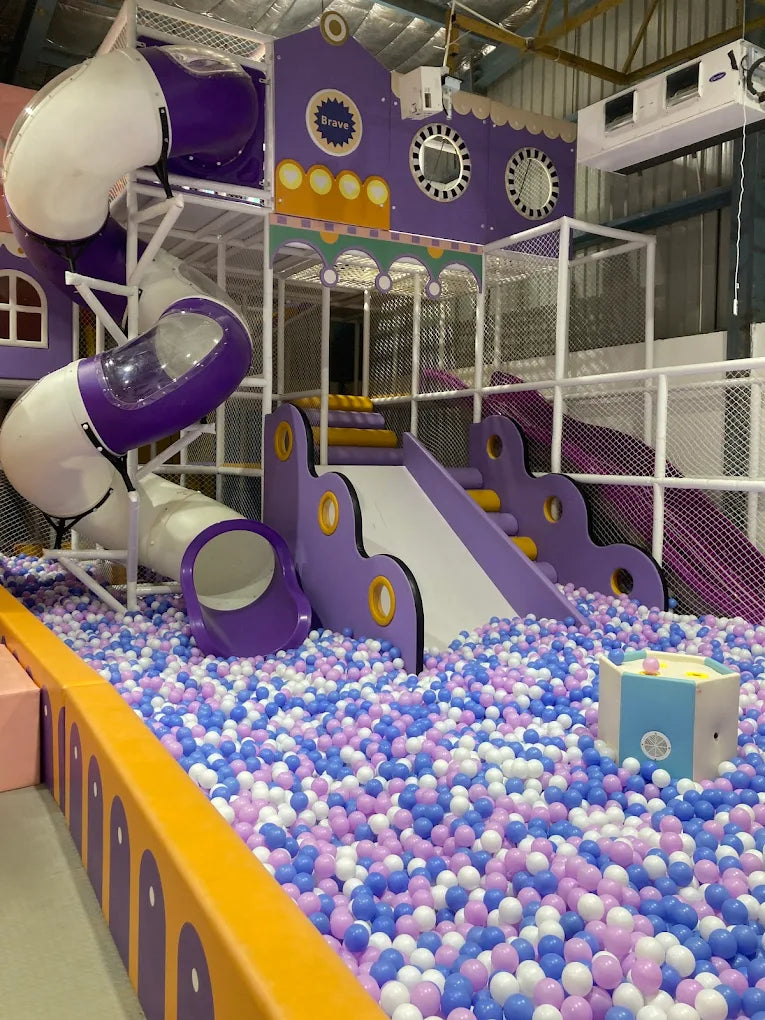 A colorful indoor playground with slides and a ball pit for children.