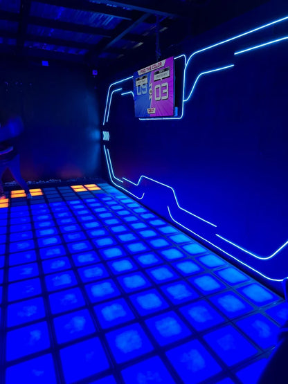 A neon-lit arcade game with a digital scoreboard and glowing blue floor.