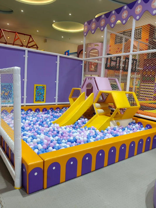 A colorful indoor playground with a ball pit and slides for young children.