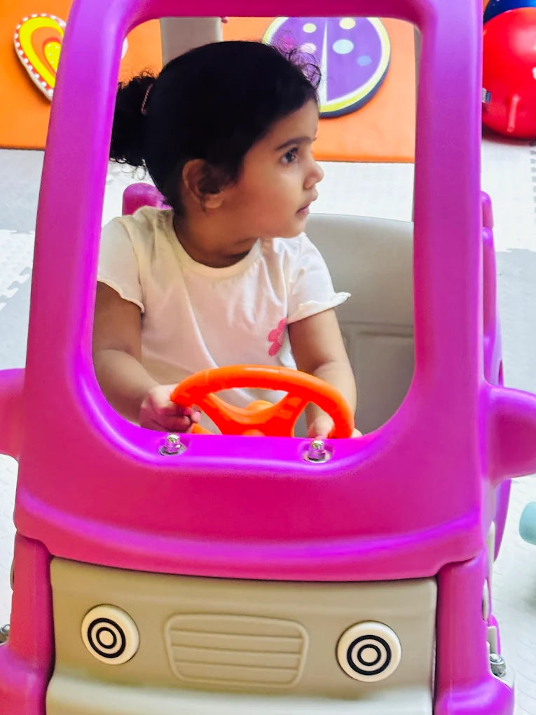 Young child steering a bright pink toy car in a vibrant indoor play zone at Sky Gamer Sector 12 Faridabad