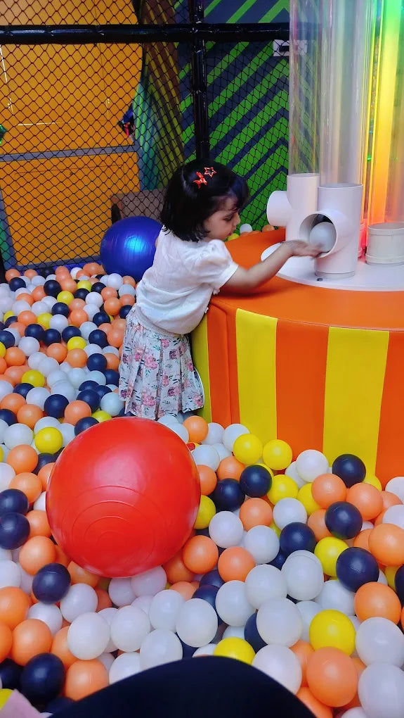 Young girl playing in colorful ball pit with interactive light tubes at Sky Gamer arcade Zone Sector 12 Faridabad