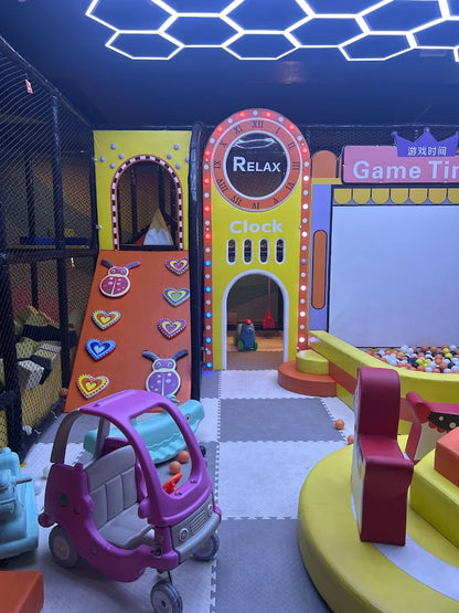 Indoor play area with toy car, colorful climbing wall, and ball pit under neon hexagonal ceiling lights at Sector 12 Faridabad