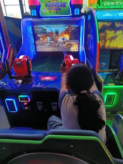 Child playing water shooting arcade game with glowing controls in vibrant Sky Gamer arcade zone Sector 12 Faridabad