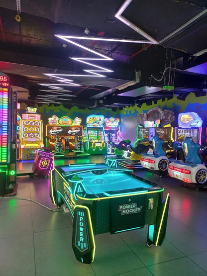Neon-lit air hockey table surrounded by various glowing arcade games at Sky Gamer Sector 12 Faridabad