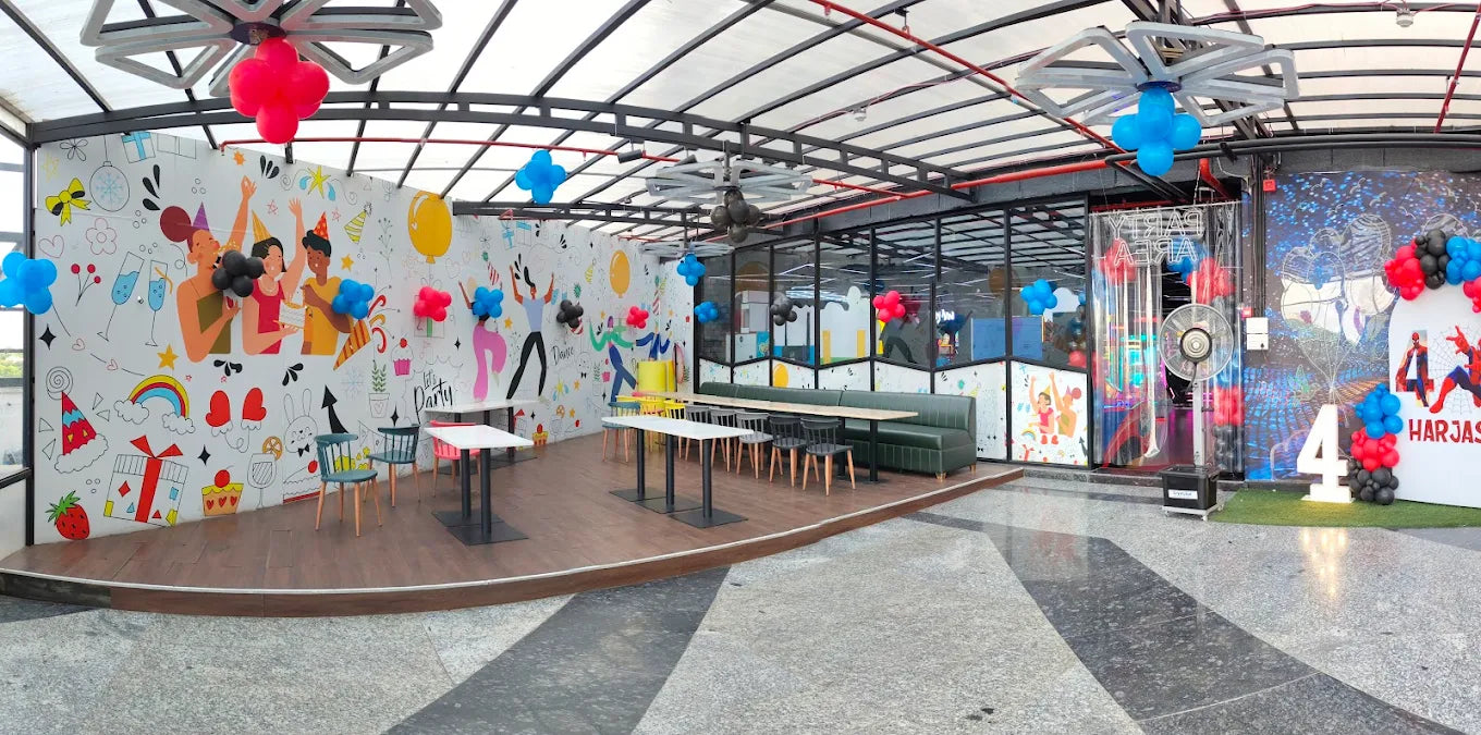 Bright party area with colorful balloons, wall art, and seating inside Sky Gamer Sector 12 Faridabad arcade zone
