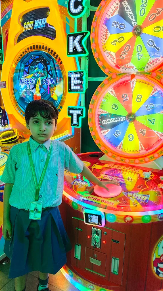 Child playing a colorful arcade ticket redemption game with spinning prize wheels at Sky Gamer Sector 12 Faridabad