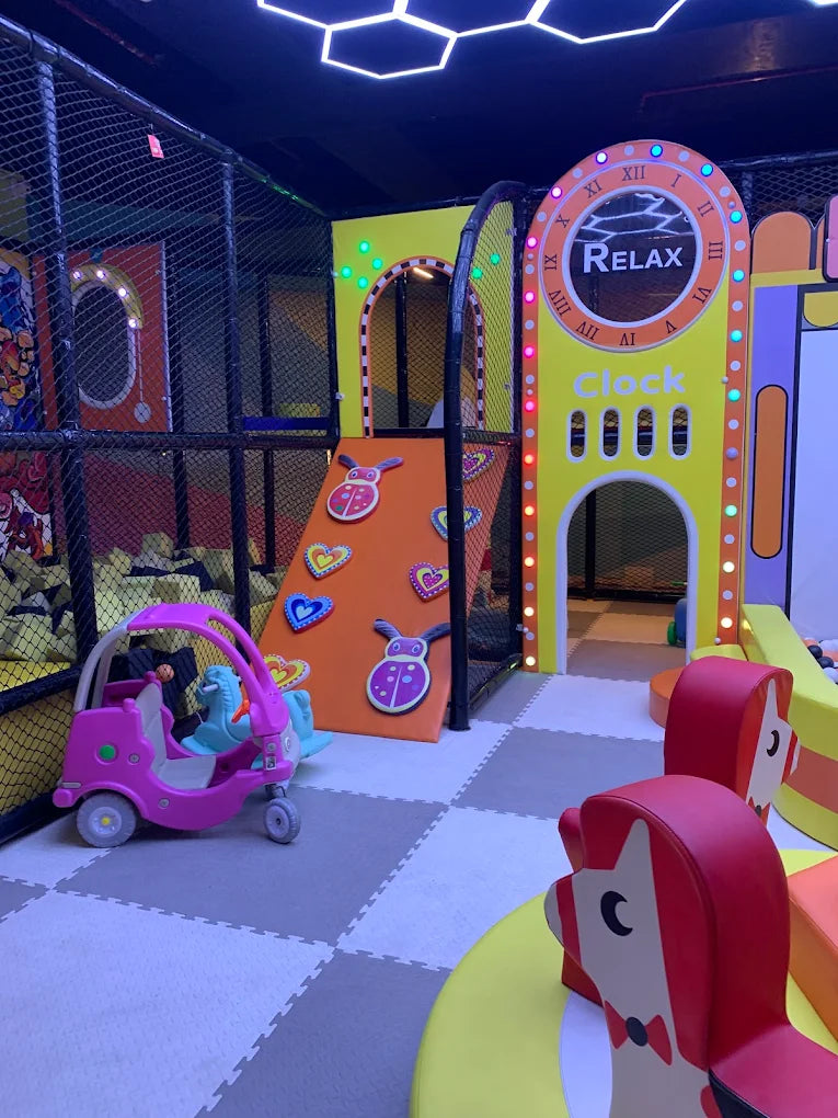 Indoor play area with colorful climbing wall, toy car, and bright clock-themed archway at Sky Gamer Sector 12 Faridabad