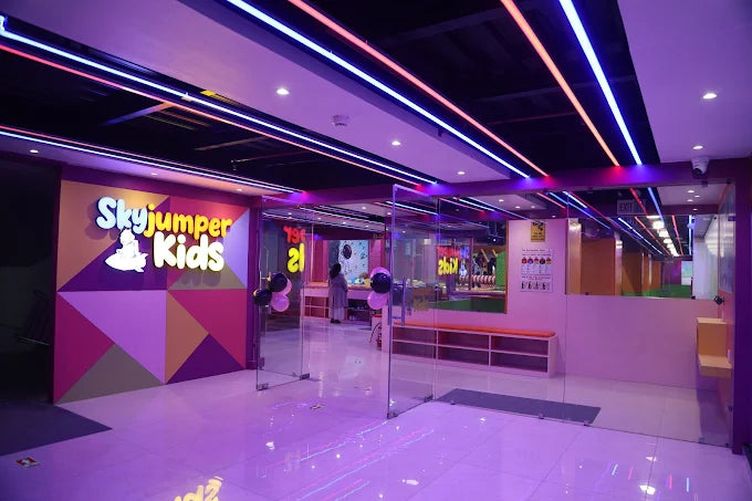 Entrance area of SkyJumper Kids trampoline park with colorful geometric walls and neon ceiling lights at Metro World Mall Gurgaon